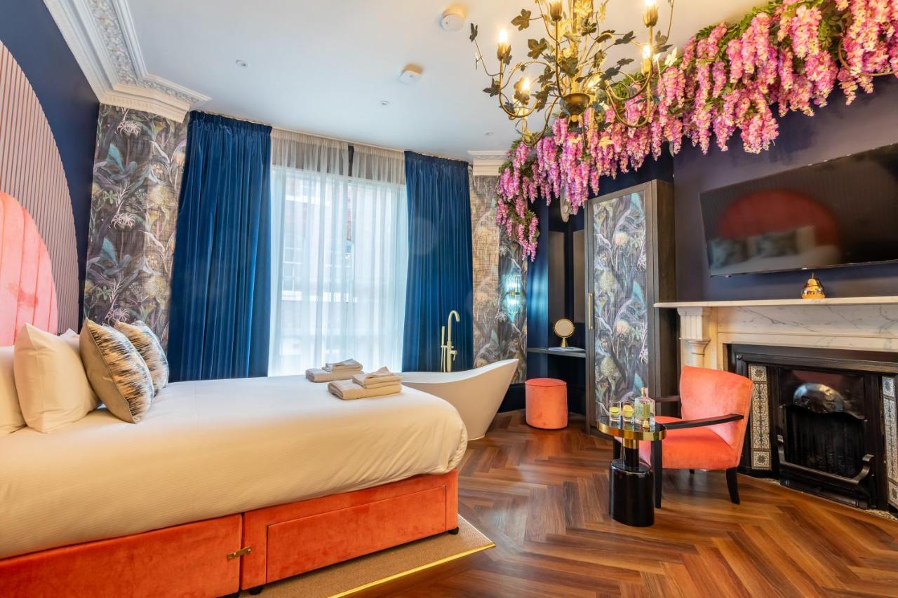 a bedroom with a tub and a bed and a fireplace at 34 Coney Street in York